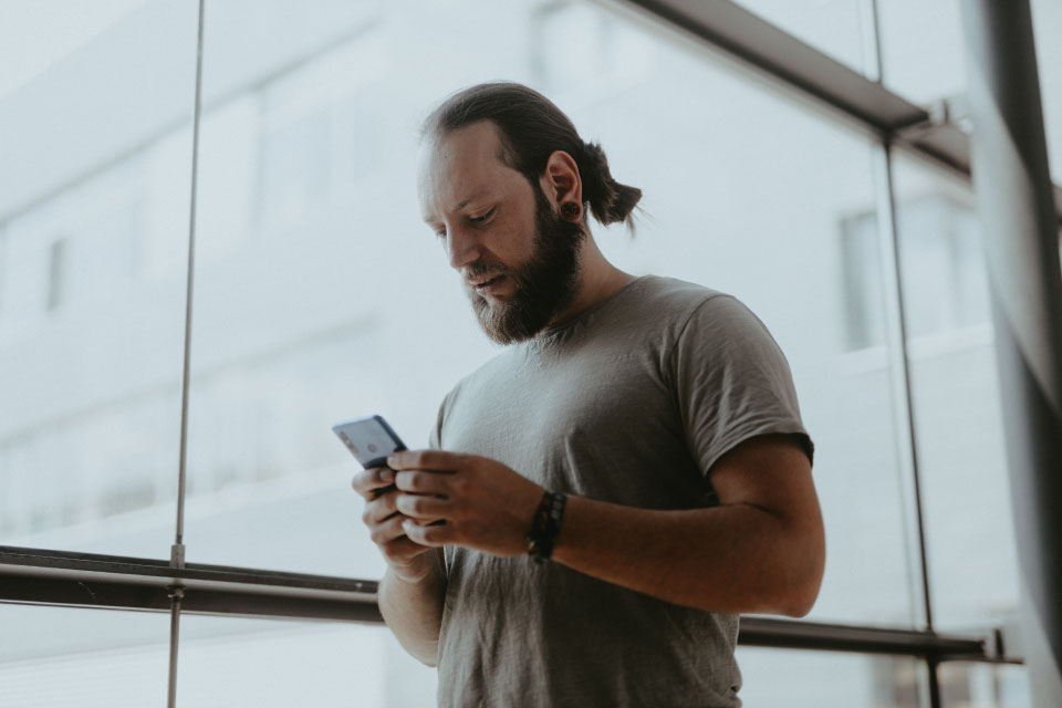 Frank Junger von miraculix mit einem Handy in der Hand