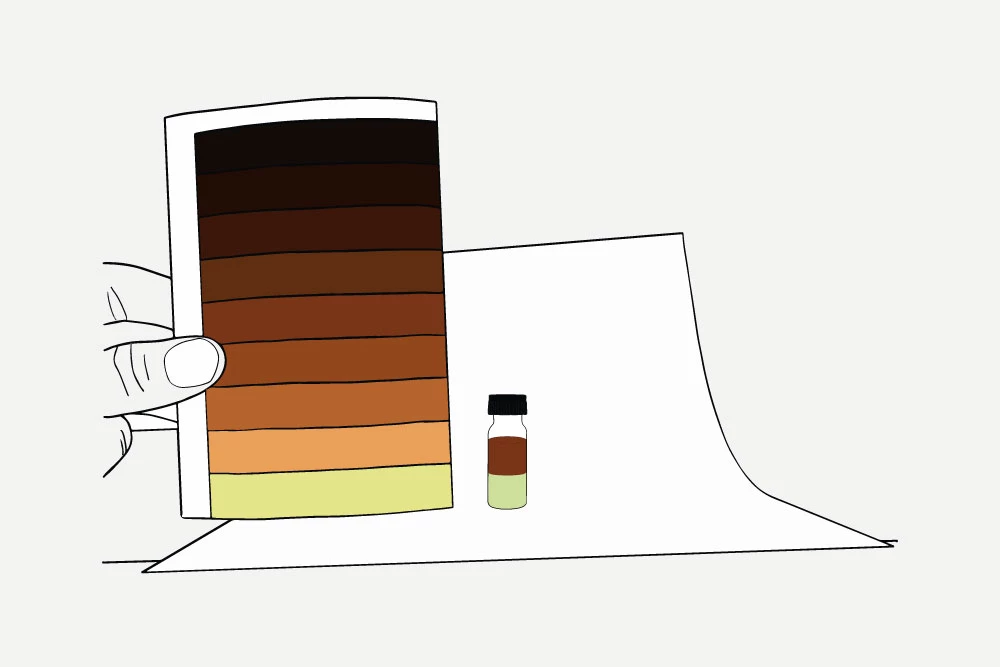 Colored vial stands next to a color chart which is held in front of a white paper background